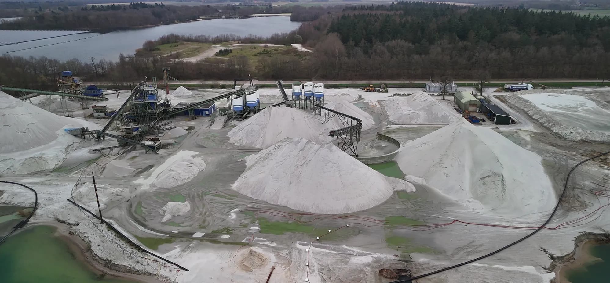 Zanddepots en een zeefinstallatie bij een zandwinning, vanuit de lucht ingemeten